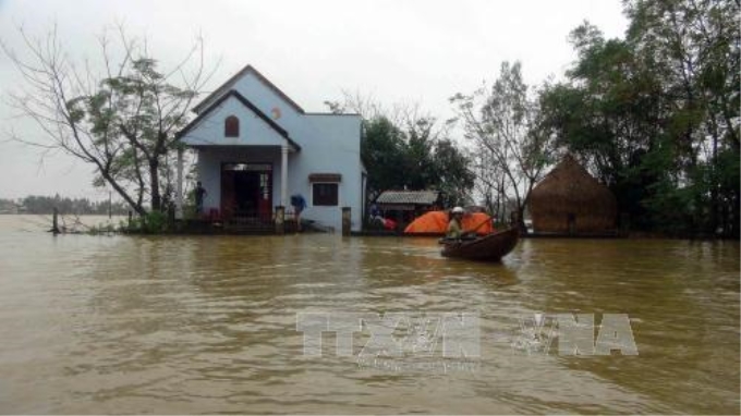 Người dân trong vùng ngập lụt do mưa lũ ở huyện Thăng Bình (tỉnh Quảng Nam) di chuyển đi lại bằng ghe, thuyền. Ảnh: TTXVN